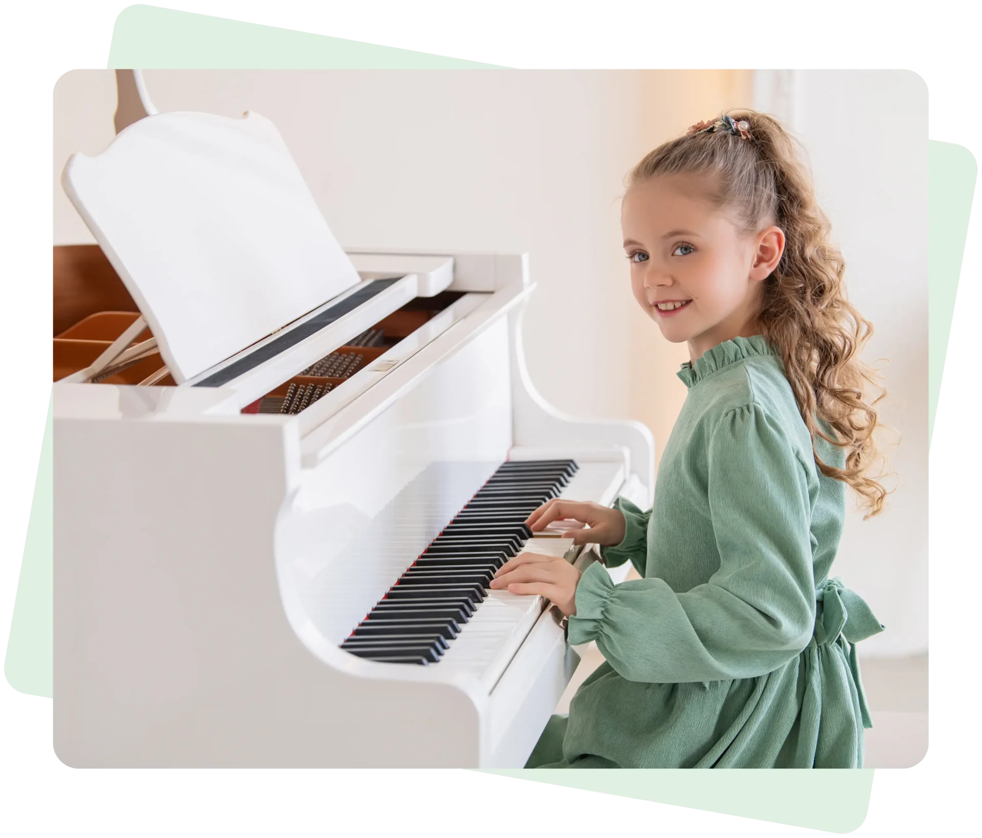 Girl playing a white piano, smiling warmly.